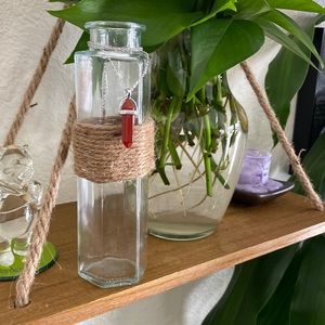 Glass vase with a crystal necklace and plant trimmings